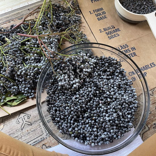 Glass bowl filled with small black objects on a wooden surface